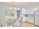 Bright kitchen featuring white cabinets, stainless steel appliances, and a breakfast nook dining area at 3613 Hope Valley Rd, Durham, NC 27707