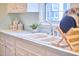 Close-up of the kitchen sink featuring a stainless steel faucet, dish rack, and natural light at 3613 Hope Valley Rd, Durham, NC 27707