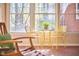 Bright sunroom with large windows, tiled floor, and yellow wicker table and chairs at 3613 Hope Valley Rd, Durham, NC 27707