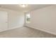 Neutral bedroom features carpet, a window with an outdoor view, and a door, creating a serene space at 396 Hopewell Branch Ct, Smithfield, NC 27577