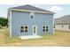 The exterior elevation of the home includes light blue siding, a patio, and lush lawn at 396 Hopewell Branch Ct, Smithfield, NC 27577