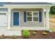 Charming home exterior featuring a blue front door, stone facade, and landscaped garden bed at 396 Hopewell Branch Ct, Smithfield, NC 27577