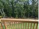 View of wooded backyard from the outdoor wooden deck and railing of the home at 4511 Mint Leaf Ln, Raleigh, NC 27612