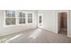 Spacious bedroom with three large windows, a door to the outside, and an attached bathroom at 4511 Mint Leaf Ln, Raleigh, NC 27612