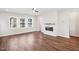 Bright living room featuring hardwood floors, a fireplace, and large windows at 4511 Mint Leaf Ln, Raleigh, NC 27612
