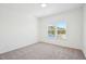 Bright bedroom featuring neutral carpet and a window offering scenic views at 556 Contempo Dr # 22, Rolesville, NC 27571