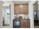 Convenient butler's pantry featuring wood cabinets, a built-in wine rack, and modern appliances at 556 Contempo Dr # 22, Rolesville, NC 27571
