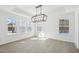 Bright dining room with hardwood floors, modern chandelier, tray ceiling, and multiple windows at 556 Contempo Dr # 22, Rolesville, NC 27571