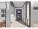 Covered front door entryway with gray door and trim, brick and siding, and house number at 556 Contempo Dr # 22, Rolesville, NC 27571