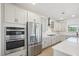 Open kitchen featuring stainless steel appliances, white cabinets, quartz countertops, and tile backsplash at 556 Contempo Dr # 22, Rolesville, NC 27571