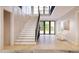 Bright entryway with wooden floors, grand staircase, black railings, and transom windows providing natural light at 5808 Norwood Ridge Dr, Raleigh, NC 27614