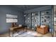 Stylish home office boasts custom built-in shelving, modern lighting, and comfortable seating area at 5808 Norwood Ridge Dr, Raleigh, NC 27614