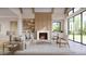 Inviting living room with fireplace, wood beam ceiling accents, large windows, stylish furnishings, and custom built-ins at 5808 Norwood Ridge Dr, Raleigh, NC 27614