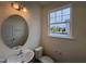 Half bathroom with a stylish oval mirror and natural light creates a fresh and inviting space at 6401 Granite Quarry Dr, Raleigh, NC 27610