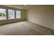 Sunlit bedroom boasts plush carpeting, neutral paint, and large windows, creating a cozy and inviting retreat at 6401 Granite Quarry Dr, Raleigh, NC 27610