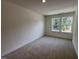 Bright bedroom with plush carpeting, a large window and neutral paint at 6403 Granite Quarry Dr, Raleigh, NC 27610