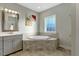 Bathroom featuring soaking tub and a large mirror at 6609 Truxton Ln, Raleigh, NC 27616