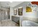 Luxurious bathroom featuring double vanities, soaking tub, walk-in shower, and artistic wall decor at 6609 Truxton Ln, Raleigh, NC 27616
