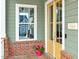 Charming front door with yellow trim, brick accents, and a lovely flower arrangement at 6609 Truxton Ln, Raleigh, NC 27616