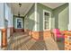 Inviting front porch featuring wood flooring, white columns, and charming wicker furniture at 6609 Truxton Ln, Raleigh, NC 27616