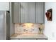 Close up of kitchen featuring marble backsplash, stone countertops, and custom cabinets at 6609 Truxton Ln, Raleigh, NC 27616