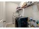 Functional laundry room with washer, dryer, shelves, and ironing board, maximizing space and convenience at 6609 Truxton Ln, Raleigh, NC 27616