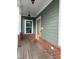 Cozy porch with brick accents, wooden floors, and a vibrant welcome mat at 6609 Truxton Ln, Raleigh, NC 27616