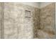 Stylish shower with neutral-toned tile, built-in niche, and bench, providing a relaxing spa experience at 6609 Truxton Ln, Raleigh, NC 27616