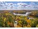 Scenic aerial view of lake house with autumn foliage and waterfront access at 721 Jones Ferry Rd, Chapel Hill, NC 27516