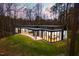 An aerial view of a modern home nestled in the woods with floor to ceiling windows at 721 Jones Ferry Rd, Chapel Hill, NC 27516