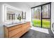 Bright bathroom with double vanity, soaking tub, and large window with nature view at 721 Jones Ferry Rd, Chapel Hill, NC 27516
