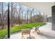 Covered patio with chairs overlooking the backyard with scenic views of the woods and greenery at 721 Jones Ferry Rd, Chapel Hill, NC 27516