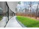 Exterior patio along the back of the home with a view of the well manicured lawn and surrounding woods at 721 Jones Ferry Rd, Chapel Hill, NC 27516