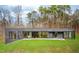 Exterior view of the modern home, landscaped lawn, and patio with outdoor seating at 721 Jones Ferry Rd, Chapel Hill, NC 27516