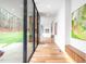 Bright, modern hallway with hardwood floors and walls of glass overlooking the greenery at 721 Jones Ferry Rd, Chapel Hill, NC 27516