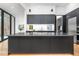 Sleek kitchen island featuring black countertops and cabinetry, and pendant lighting at 721 Jones Ferry Rd, Chapel Hill, NC 27516