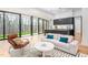 Open-concept living room with modern decor, expansive windows, and a connected kitchen at 721 Jones Ferry Rd, Chapel Hill, NC 27516