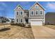 Inviting two-story home featuring a two-car garage, blue door, and a meticulously maintained landscaped front yard at 7331 Livestock Rd, Mebane, NC 27302