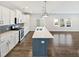 Spacious kitchen with quartz counters, stainless steel appliances, island, and open view to the living area at 7331 Livestock Rd, Mebane, NC 27302