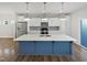 Modern kitchen with white cabinets, stainless steel appliances, and a blue island with a white countertop at 7331 Livestock Rd, Mebane, NC 27302