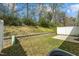 Backyard with a patio, retaining wall, greenery, and air conditioning unit, creating a private outdoor space at 818 Houston Ct, Haw River, NC 27258