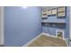Blue laundry room with hardwood floors, built-in shelves and space for appliances hookups at 818 Houston Ct, Haw River, NC 27258