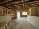 Unfinished basement with exposed wooden beams, visible wiring, and a temporary door at 95 Parkland Dr, Pittsboro, NC 27312