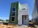 A modern two-story home featuring large windows, green sheathing, and white siding under a clear blue sky at 95 Parkland Dr, Pittsboro, NC 27312