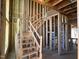 Interior view of unfinished staircase, exposed framing, and visible wiring in a new construction home at 95 Parkland Dr, Pittsboro, NC 27312