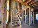Interior view of unfinished staircase, exposed framing, and visible wiring in a new construction home at 95 Parkland Dr, Pittsboro, NC 27312