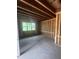 Unfinished room featuring exposed framing, concrete floors, and a window offering natural light during construction at 95 Parkland Dr, Pittsboro, NC 27312