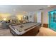 Spacious finished basement with a pool table, comfortable seating area and bright turquoise accent cabinet at 1025 Chelsea Run Ln, Apex, NC 27502