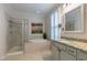 Bathroom featuring granite countertops, garden tub, glass enclosed shower and large window with plantation shutters at 1025 Chelsea Run Ln, Apex, NC 27502