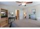 Cozy bedroom featuring a ceiling fan, television on bookcase, and a door leading into an ensuite bathroom at 1025 Chelsea Run Ln, Apex, NC 27502